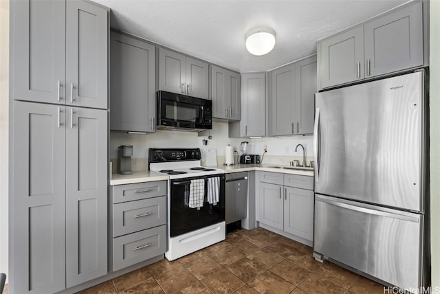 kitchen featuring gray cabinets, a textured ceiling, stainless steel appliances, and sink