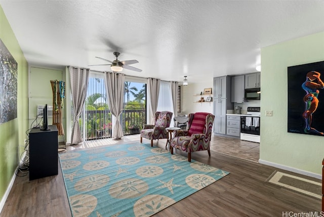 sitting room with a textured ceiling, dark hardwood / wood-style floors, and ceiling fan