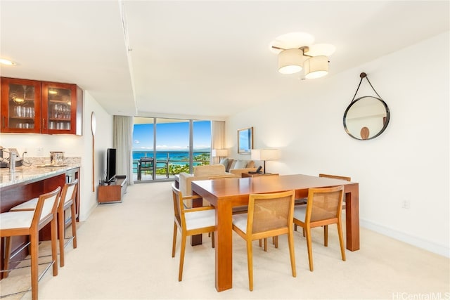 carpeted dining area featuring floor to ceiling windows