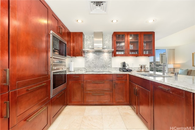 kitchen featuring black electric stovetop, oven, wall chimney exhaust hood, light stone counters, and built in microwave