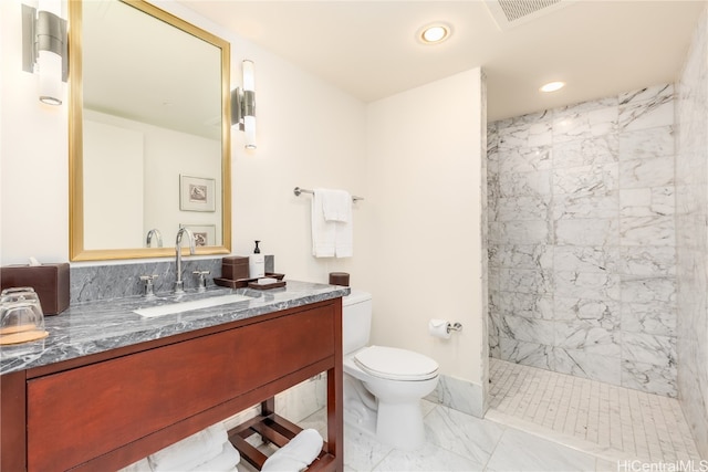 bathroom featuring vanity, toilet, and tiled shower