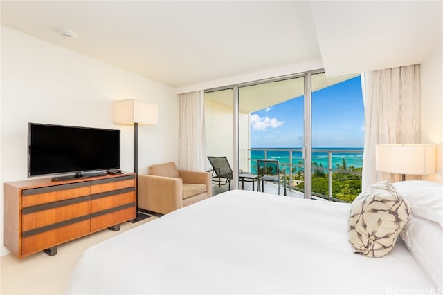 bedroom with a water view, carpet flooring, a wall of windows, and access to exterior