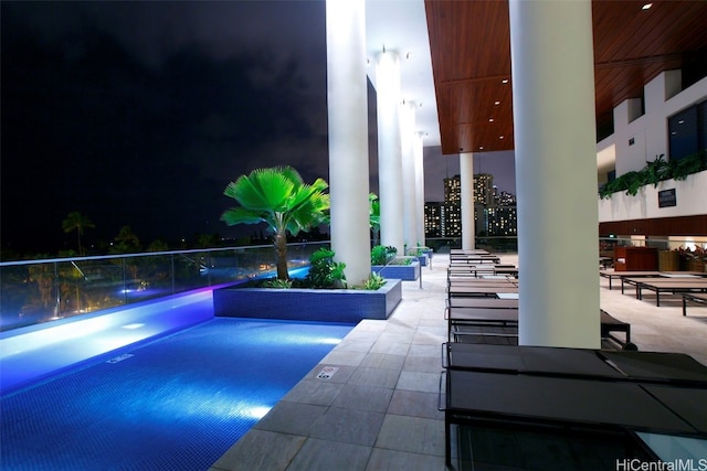 pool at night with a patio area