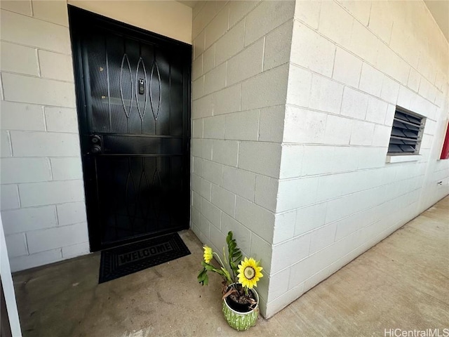 doorway to property featuring concrete block siding