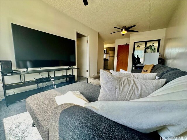 living area with carpet floors, a textured ceiling, and ceiling fan