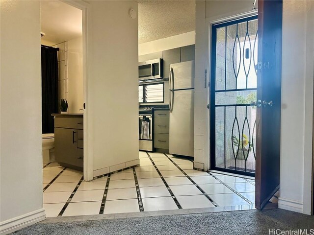 entrance foyer featuring light tile patterned floors and baseboards