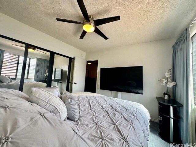 bedroom with ceiling fan, carpet, and a textured ceiling