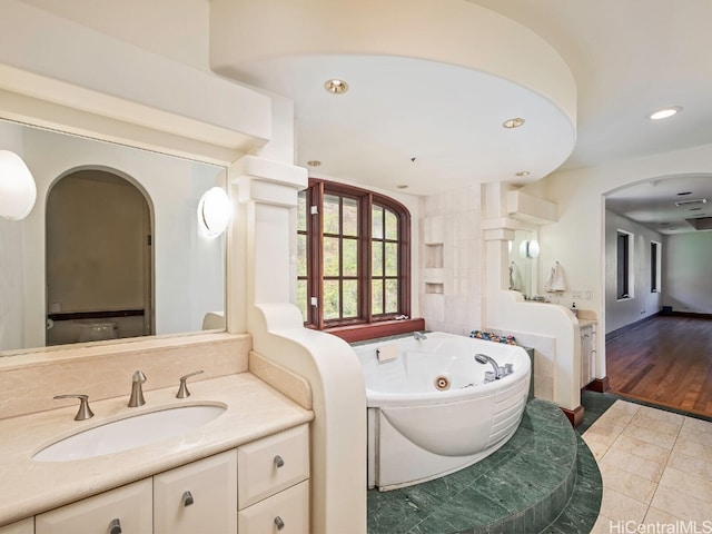 bathroom with vanity, wood-type flooring, and a bathtub