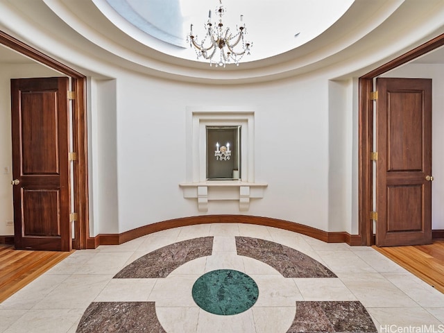 corridor featuring an inviting chandelier and light hardwood / wood-style flooring