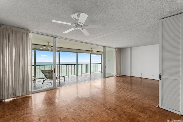 2877 Kalakaua Ave Unit 301, Honolulu, HI 96815 - unfurnished room featuring ceiling fan, a textured ceiling, a water view, and floor to ceiling windows