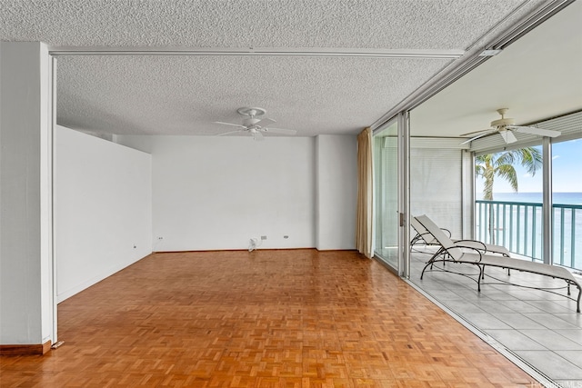 2877 Kalakaua Ave Unit 301, Honolulu, HI 96815 - empty room featuring ceiling fan, floor to ceiling windows, a textured ceiling, and a water view
