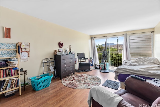 bedroom with access to exterior and hardwood / wood-style flooring