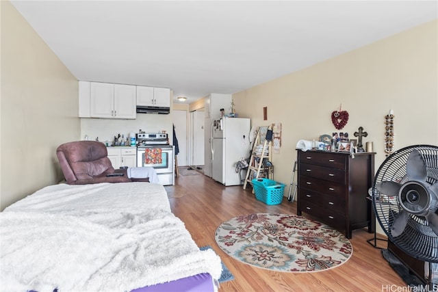 bedroom with hardwood / wood-style flooring and white refrigerator