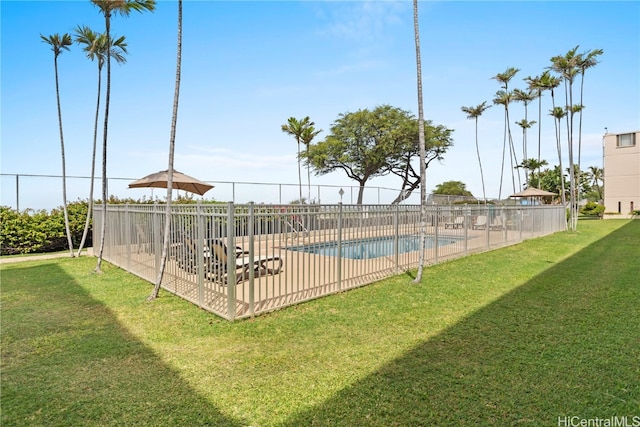 view of pool with a patio and a lawn