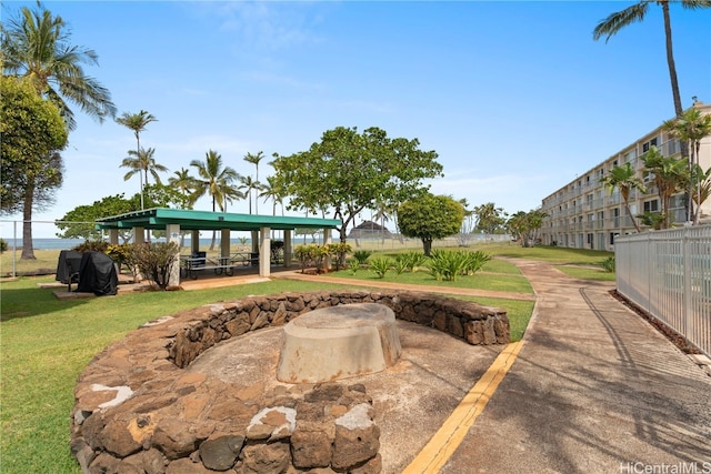 view of community featuring a fire pit and a yard