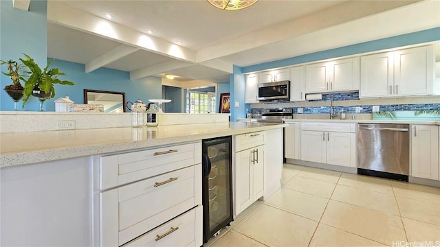84-879 Moua St, Waianae, HI 96792 - kitchen featuring sink, tasteful backsplash, stainless steel appliances, beverage cooler, and white cabinets