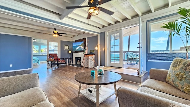 living room with hardwood / wood-style floors, beam ceiling, and ceiling fan