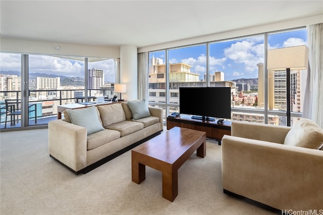 living room with a wall of windows and light colored carpet