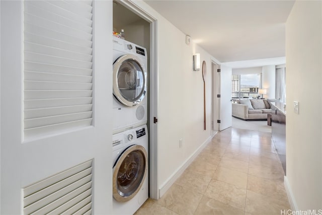 laundry area featuring stacked washer and dryer and light tile patterned floors