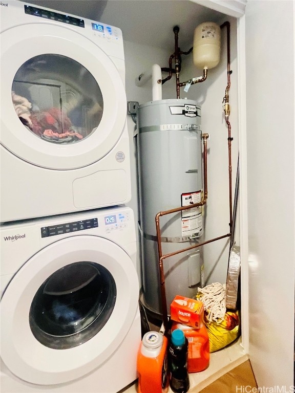 clothes washing area featuring water heater and stacked washer and dryer