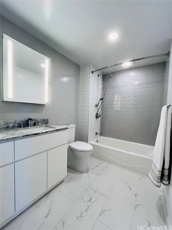 full bathroom featuring vanity, tiled shower / bath, and toilet