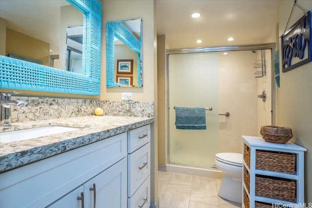 bathroom with toilet, a shower with shower door, and vanity