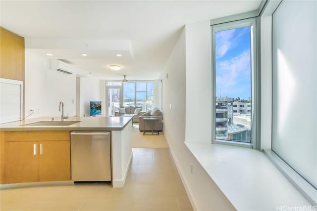 kitchen featuring light brown cabinets, a wall mounted AC, stainless steel dishwasher, and sink