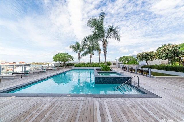 view of swimming pool with a hot tub and a patio