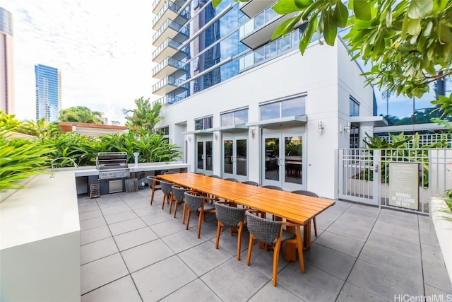 view of patio / terrace with area for grilling, french doors, and a balcony