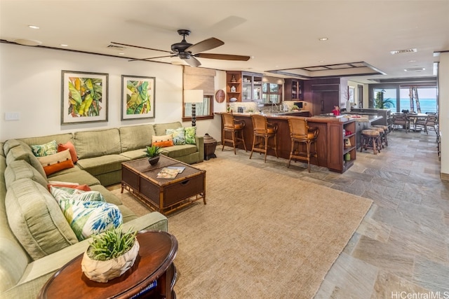 living room with a water view and ceiling fan