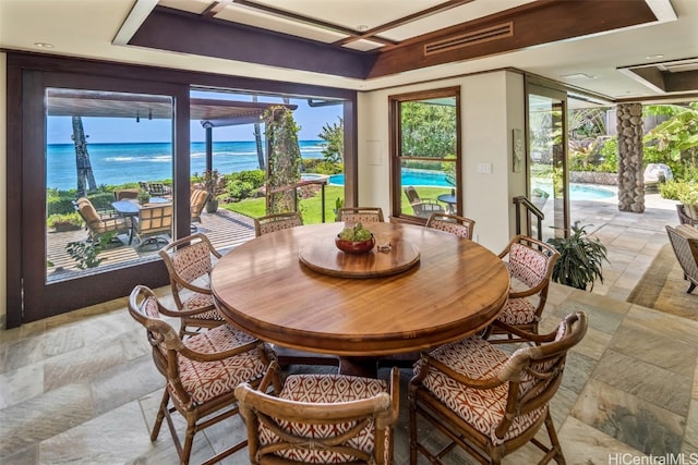 dining space with a healthy amount of sunlight and a water view