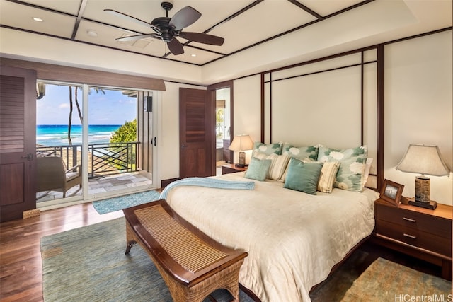 bedroom featuring access to exterior, hardwood / wood-style flooring, a water view, and ceiling fan