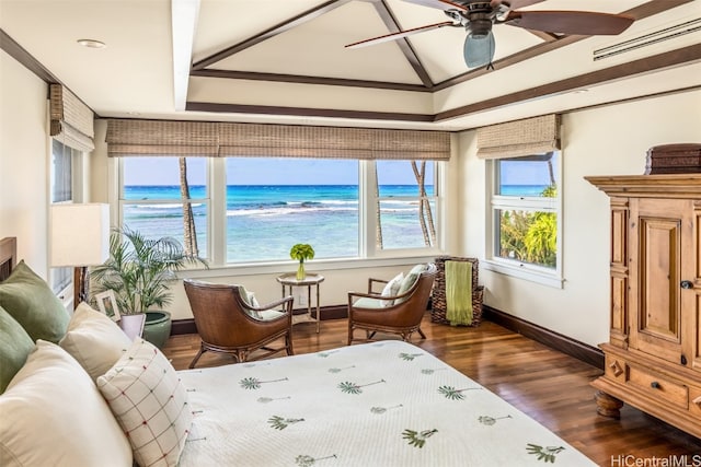 sunroom with a view of the beach, a water view, and ceiling fan