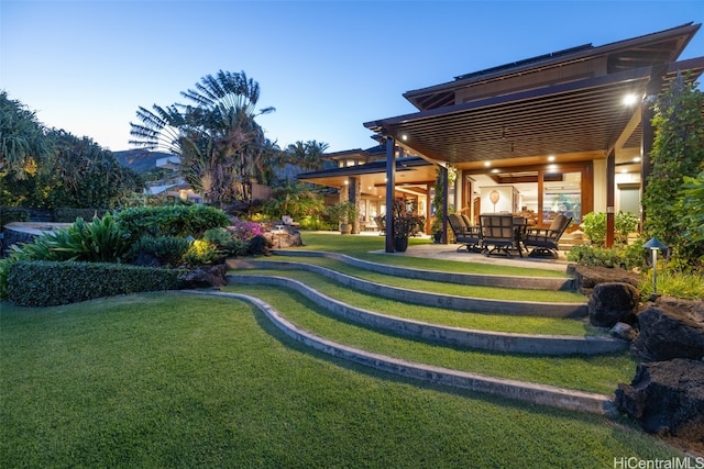 yard at dusk with a patio area