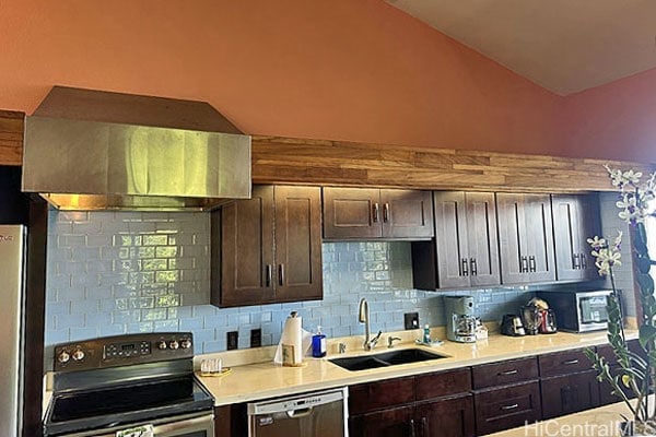 kitchen with vaulted ceiling, electric range oven, sink, and stainless steel dishwasher