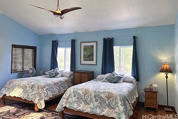 bedroom with multiple windows, hardwood / wood-style floors, vaulted ceiling, and ceiling fan