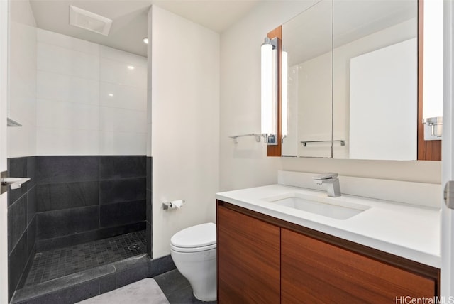 full bathroom featuring vanity, visible vents, a walk in shower, tile patterned floors, and toilet