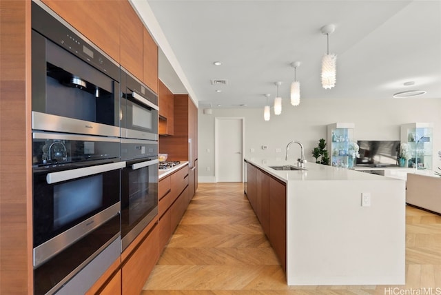 kitchen with a sink, modern cabinets, brown cabinetry, and appliances with stainless steel finishes