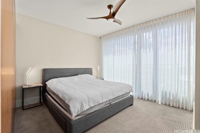 carpeted bedroom with baseboards and ceiling fan