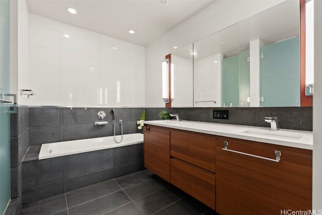 full bathroom featuring tile patterned floors, a sink, tile walls, double vanity, and a bath