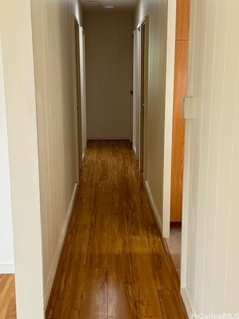 hall featuring wooden walls and dark hardwood / wood-style flooring