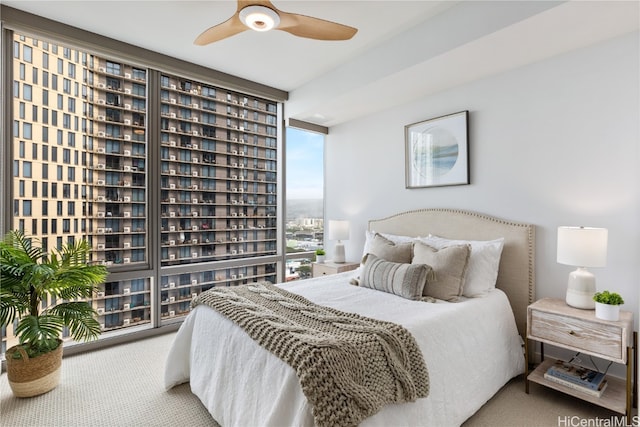 bedroom with carpet, expansive windows, and ceiling fan