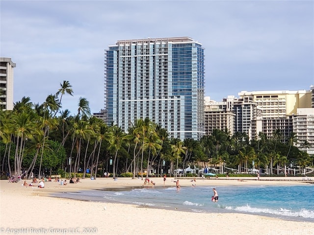 view of property with a water view and a beach view