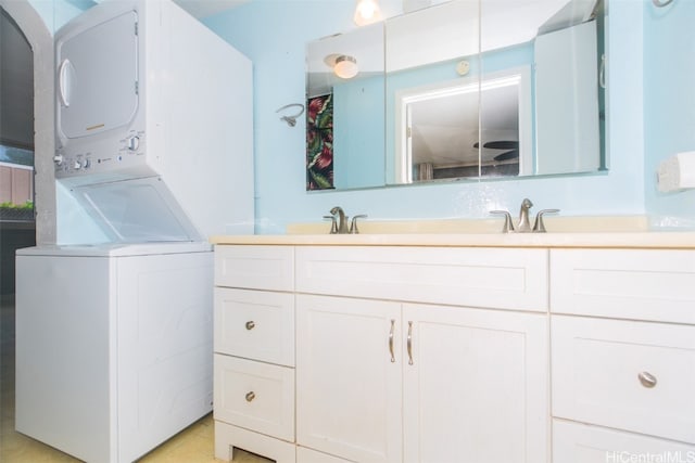 bathroom with stacked washer and dryer and sink