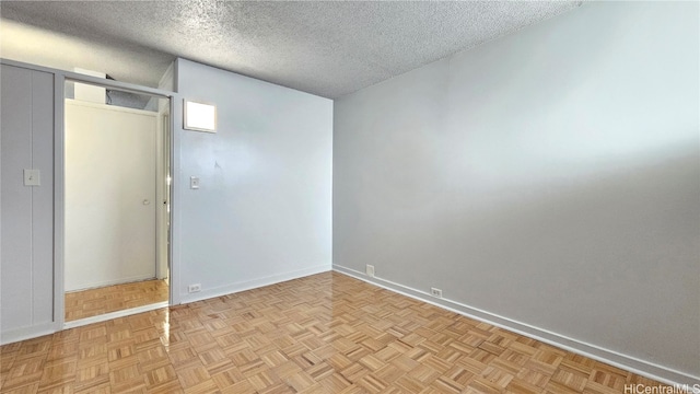 interior space with a textured ceiling and light parquet floors