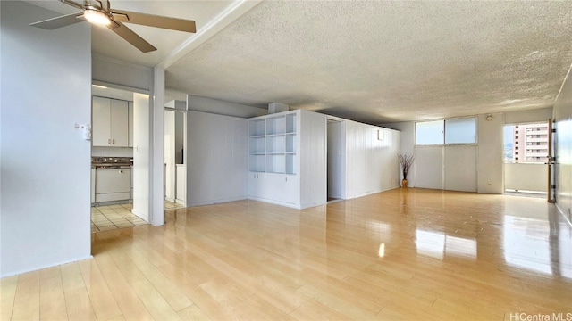 empty room featuring light hardwood / wood-style flooring, a textured ceiling, and ceiling fan