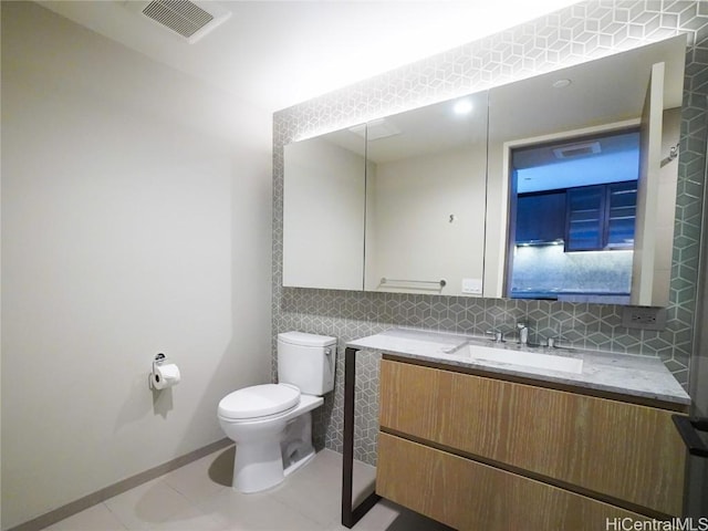 bathroom featuring tasteful backsplash, tile patterned floors, vanity, and toilet