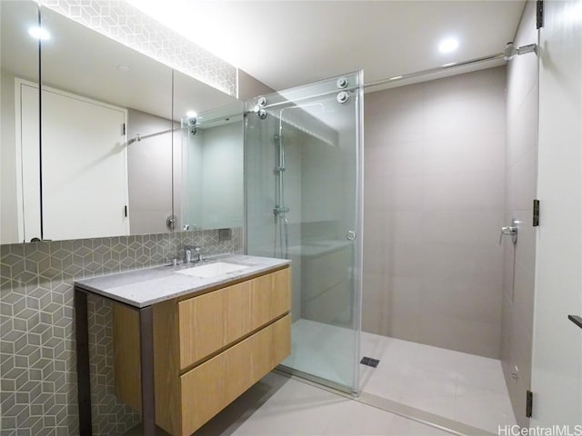 bathroom featuring backsplash, tile patterned floors, vanity, and walk in shower