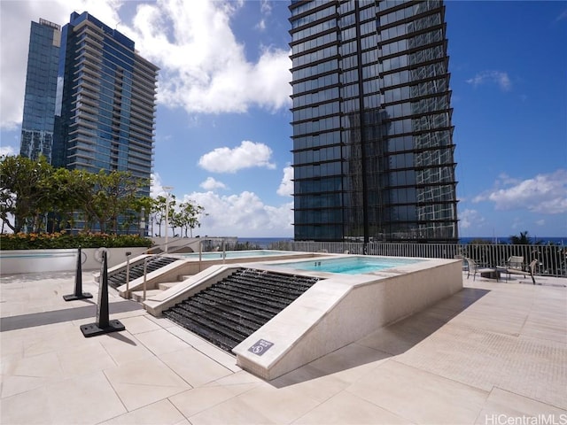 view of swimming pool with a hot tub