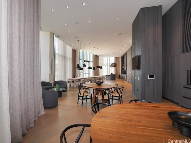 dining area with floor to ceiling windows and light hardwood / wood-style floors